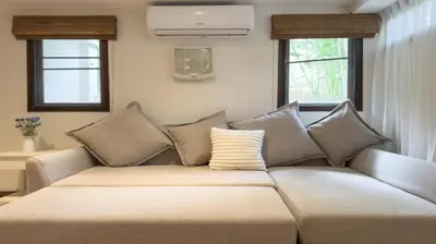 a couch in a living room with two windows at Tropical Poolside Villa - SGB4 in Phuket Town