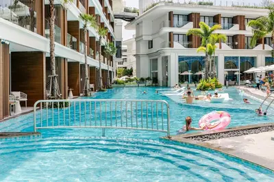 a swimming pool at a resort with people in it at Sunshine by Villacarte in Layan Beach