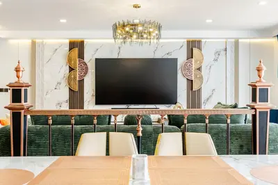 a dining room with a television and a table and chairs at Sunshine by Villacarte in Layan Beach