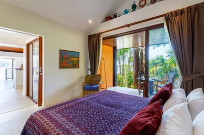 a bedroom with a bed and a large window at Seafront Pool Villa Nambo in Ko Taphao Noi