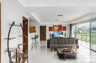 a living room with a couch and a table at Condominium Rawai D1 - near convenience beach, market, gym in Rawai Beach