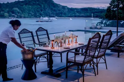 a woman standing next to a table with chairs at Villa Eugenia in Phuket Town