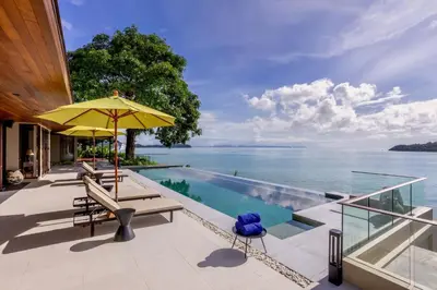 a swimming pool with a view of the water at Villa Eugenia in Phuket Town