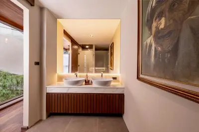 a bathroom with two sinks and a painting on the wall at Villa Eugenia in Phuket Town