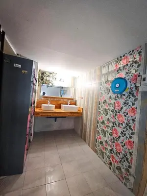 a bathroom with two sinks and a floral wall at MT friendhome&hostel2 in Phuket Town