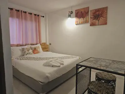 a small bedroom with a bed and a table at MT friendhome&hostel2 in Phuket Town