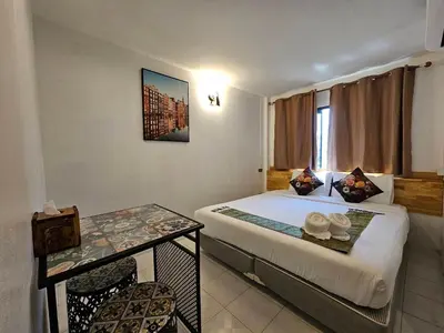 a hotel room with a bed and a table and chairs at MT friendhome&hostel2 in Phuket Town