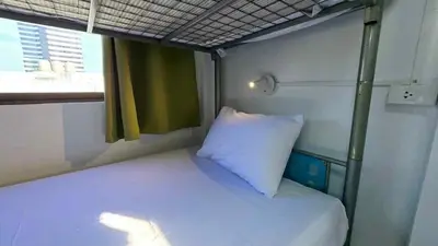 a small bed in a small room with a pillow at MT friendhome&hostel2 in Phuket Town