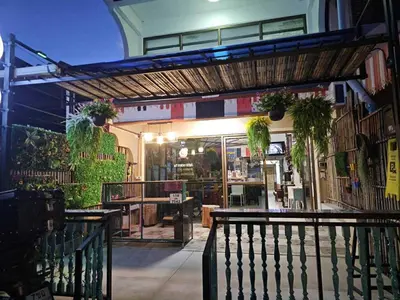 a building with a porch with plants on it at MT friendhome&hostel2 in Phuket Town
