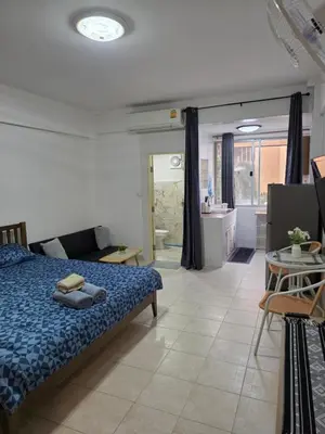 a bedroom with a bed and a table and a kitchen at Monkey Apartment 38 in Patong Beach