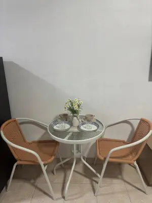 a table with two chairs and a vase with flowers on it at Monkey Apartment 38 in Patong Beach