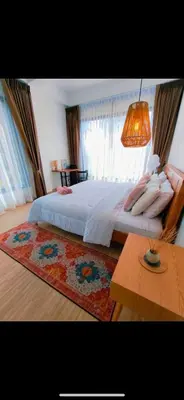 a bedroom with a large white bed with a rug at Chaota Modern House in Ban Ao Makham