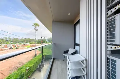 a balcony with a chair and a view of a street at Diamond Condominium Phuket 2BR 5 min to Bangtao beach in Bang Tao Beach