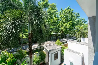 a view from the balcony of a house with palm trees at Private pool villa in the heart of Bangtao in Bang Tao Beach