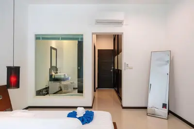 a bedroom with a bed and a large mirror at Private pool villa in the heart of Bangtao in Bang Tao Beach