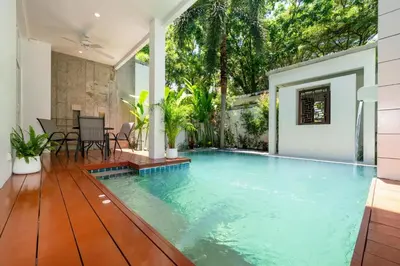 an infinity pool in a house with a table and chairs at Private pool villa in the heart of Bangtao in Bang Tao Beach