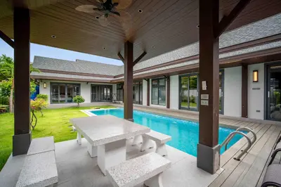 an outdoor patio with a table and a pool at summer stay pool villa in Ban Na Bon