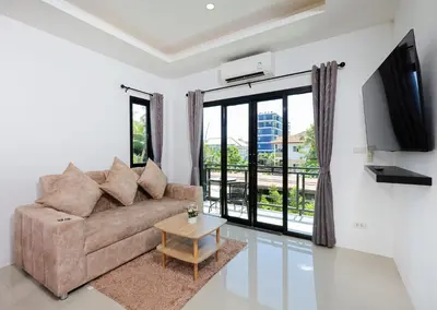 a living room with a couch and a table at RinFin Beach House - Bangtao in Ban Thalat Choeng Thale