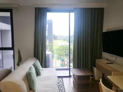 a hotel room with a couch and a large window at Sky Park Laguna F4 in Laguna Phuket