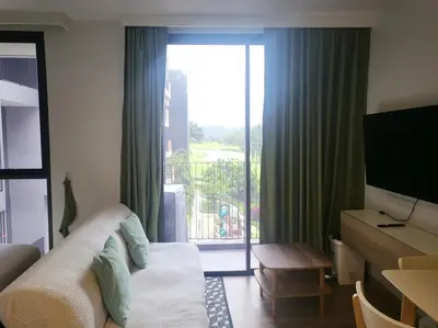 a hotel room with a bed and a sliding glass door at Sky Park Laguna F4 in Laguna Phuket