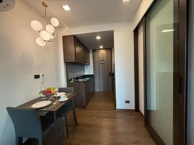 a kitchen and dining room with a table and chairs at New 1BR Apartment in The Proud Karon Phuket in Karon Beach