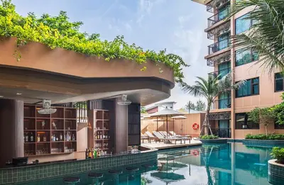 a swimming pool in front of a building at New 1BR Apartment in The Proud Karon Phuket in Karon Beach