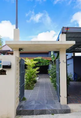 a walkway leading into a building with a garage at Haleema Signature Villa - Bangtao Beach in Ban Thalat Choeng Thale