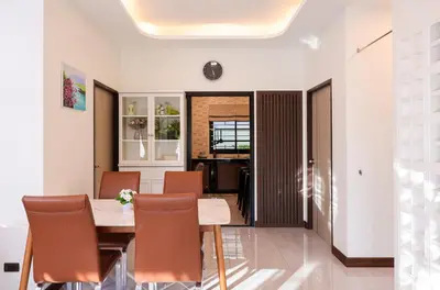 a dining room with a table and chairs at Haleema Signature Villa - Bangtao Beach in Ban Thalat Choeng Thale