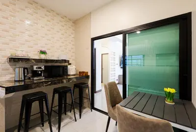 a kitchen with a table and some chairs and a counter at Haleema Signature Villa - Bangtao Beach in Ban Thalat Choeng Thale