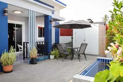 a patio with a table and an umbrella at Leema Beach Villa - Bangtao in Ban Thalat Choeng Thale