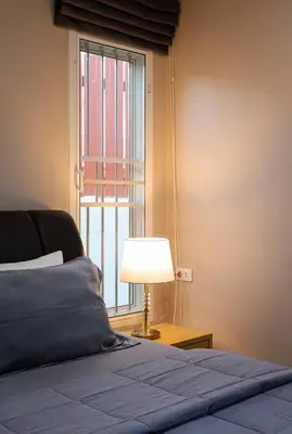 a bedroom with a bed with a lamp and a window at Leema Beach Villa - Bangtao in Ban Thalat Choeng Thale
