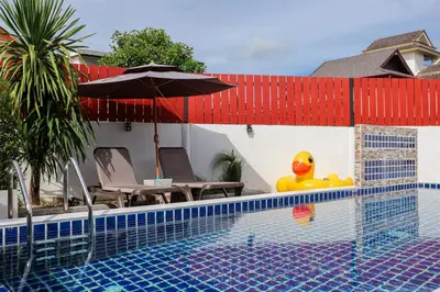 a pool with a rubber duck sitting next to a house at Leema Beach Villa - Bangtao in Ban Thalat Choeng Thale