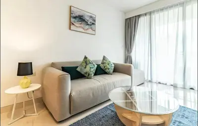 a living room with a couch and a glass table at Cassia 1 bedroom in Bang Tao Beach