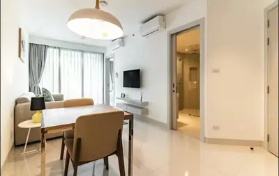a white living room with a table and a couch at Cassia 1 bedroom in Bang Tao Beach