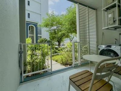 a balcony with a view of a yard at Modern 1 & 2 Bedroom Apartments Naiyang Phuket by Mango Family in Nai Yang Beach