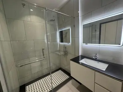 a bathroom with a sink and a glass shower at Legendary Bang Tao in Phuket