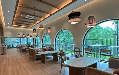 a restaurant with tables and chairs and large windows at Legendary Bang Tao in Phuket