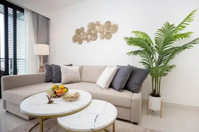 a living room with a couch and a table with fruit on it at Cassia Residences - 1BDR - Sea view in Laguna Phuket