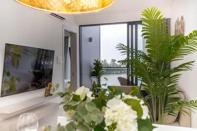 a living room with plants and a chandelier at Cassia Residences - 1BDR - Sea view in Laguna Phuket