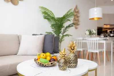 a living room with a bowl of fruit on a table at Cassia Residences - 1BDR - Sea view in Laguna Phuket