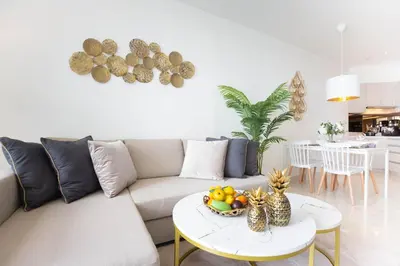 a living room with a couch and a table with a bowl of fruit at Cassia Residences - 1BDR - Sea view in Laguna Phuket