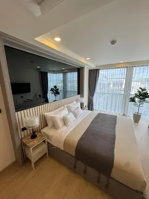 a bedroom with a large bed with a large window at New luxury condo Ozone next to Laguna in Phuket
