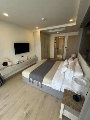 a hotel room with a large bed and a television at New luxury condo Ozone next to Laguna in Phuket