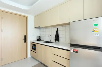a kitchen with white cabinets and a refrigerator at Fantasea Condo Kamala B502 1BDRM by Phuket Sabay Rent in Kamala Beach