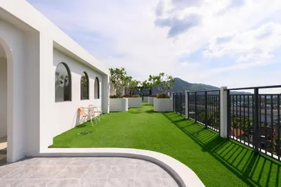 a balcony with green grass on a white building at Fantasea Condo Kamala B708 1BDRM by Phuket Sabay Rent in Kamala Beach
