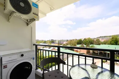 a balcony with a washing machine and a table at Fantasea Condo Kamala B708 1BDRM by Phuket Sabay Rent in Kamala Beach
