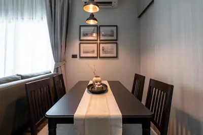a dining room with a black table and chairs at Title Halo Time For Family Pool Gym Hammam in Nai Yang Beach