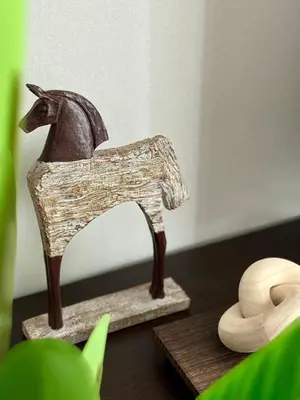 a wooden figurine of a horse on a table at Title Halo Time For Family Pool Gym Hammam in Nai Yang Beach