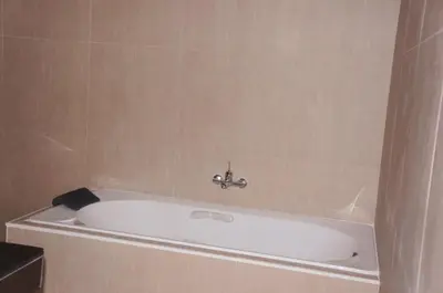 a bath tub with a faucet in a bathroom at A&J Holiday Villa in Ban Na Bon