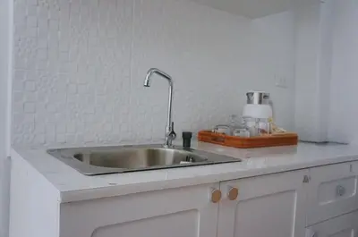 a kitchen counter with a stainless steel sink at A&J Holiday Villa in Ban Na Bon